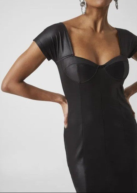 Black dress with sheer panels worn by a model on a plain background