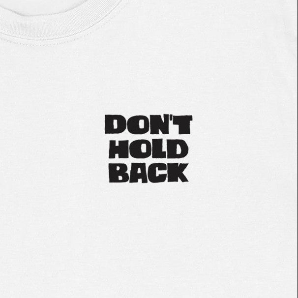 Close-up of a chest logo on a white t-shirt. It reads Don't Hold Back in chunky block capitals.