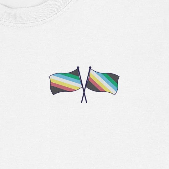 Close-up of a printed logo of two crossed Disability Pride flags on a white t-shirt. 